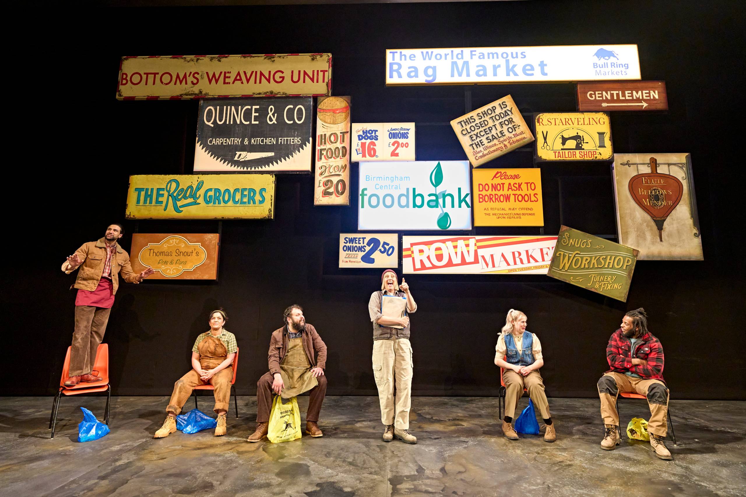 The Mechanicals perform under a selection of colourful vintage shop signs.