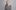 Headshot of The Lost Voice Guy, he is wearing a black and white striped jumper, he is smiling toward the camera.